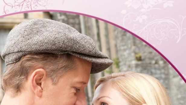 Ein Mann und eine Frau schauen sich auf dem Cover von „Rosamunde Pilcher - Liebe am Horizont“ anlächelnd an.