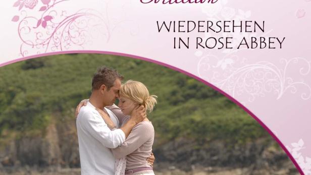 Ein Paar umarmt sich am Strand, im Hintergrund der Titel „Wiedersehen in Rose Abbey“.