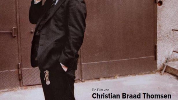 Das Filmplakat für „Fassbinder – lieben ohne zu fordern“ zeigt einen Mann mit Hut und Zigarette.