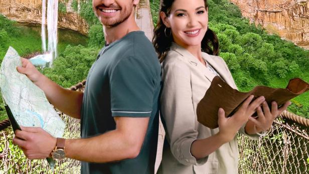 Ein Mann mit einer Karte und eine Frau mit einem Buch stehen auf einer Hängebrücke vor einer malerischen Landschaft.