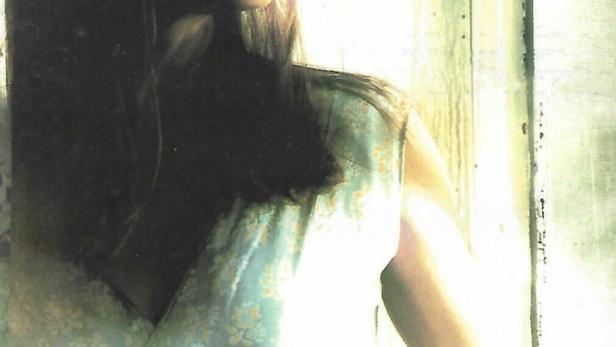 Eine Frau blickt aus dem Fenster; im Vordergrund steht „Harlan County War“.