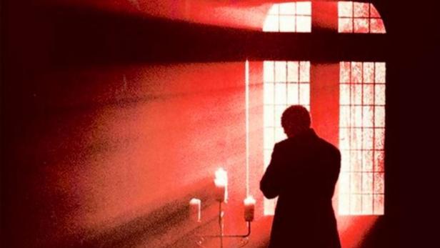 Das Filmplakat für „Possessed“ zeigt eine dunkle Silhouette vor einem Fenster mit Kerzenlicht.