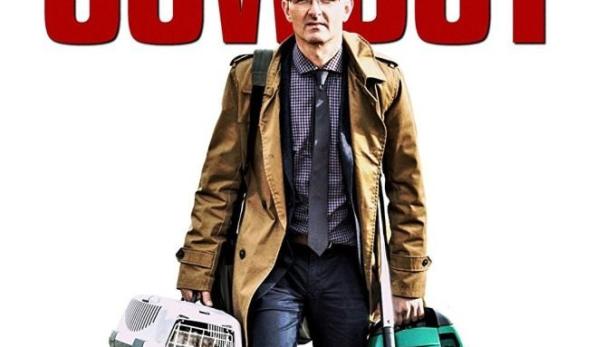 Ein Mann mit Katze in einer Transportbox und einem Staubsauger vor dem Filmtitel „Der letzte Cowboy“.