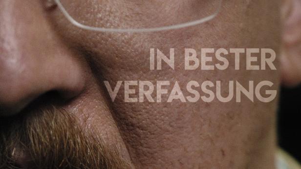 Nahaufnahme eines Mannes mit Brille und Schnurrbart, mit dem Schriftzug „In bester Verfassung“.