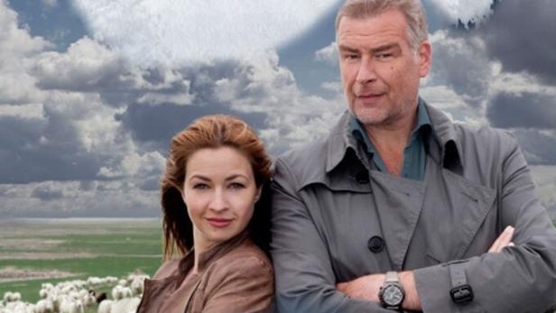 Das Filmplakat zu „Nordisch Herb“ zeigt ein Paar vor einer Schafherde und einem bewölkten Himmel.