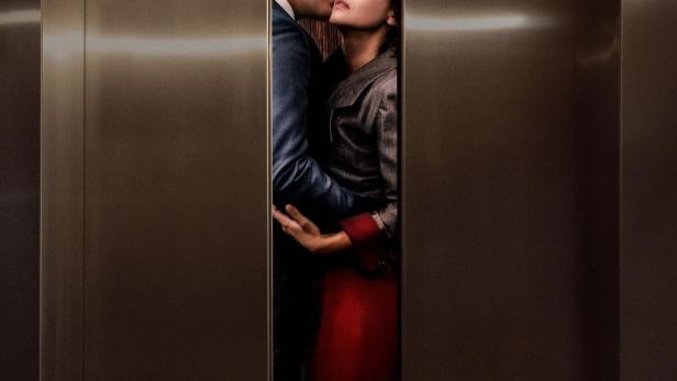 Ein Mann umarmt eine Frau in einem Aufzug.