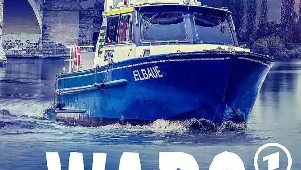Ein blau-weißes Polizeiboot mit der Aufschrift „Elbaue“ fährt auf der Elbe.