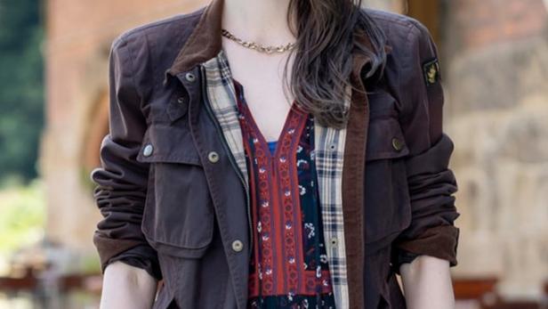 Eine Frau in Jacke und Kleid, möglicherweise ein Filmplakat für „Mandat für Mai“.