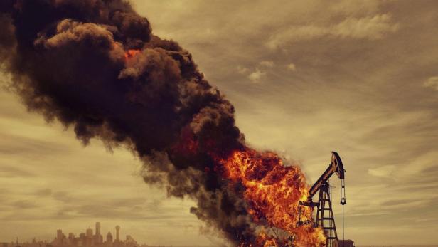 Ein Ölförderturm steht in Flammen, dicker Rauch steigt auf.