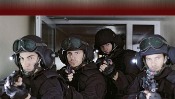 Vier GSG 9-Beamte in voller Montur zielen mit ihren Waffen.