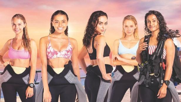 Das Filmplakat für „Dive Club“ zeigt fünf junge Frauen in Tauchausrüstung vor einem Sonnenuntergang.
