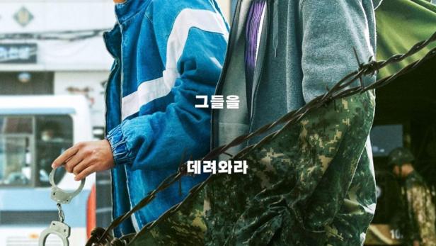 Das Filmplakat zu „D.P.“ zeigt zwei junge Männer in Militärkleidung hinter Stacheldraht.