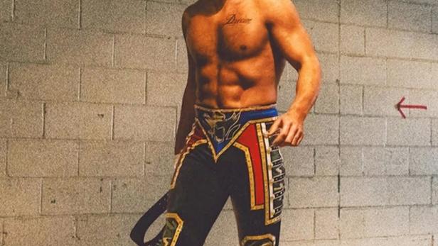 Der Wrestler Cody Rhodes posiert vor einer Ziegelwand für WWE Unreal.