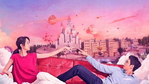 Ein Mann und eine Frau liegen auf einem roten Sofa vor einer Fantasielandschaft.