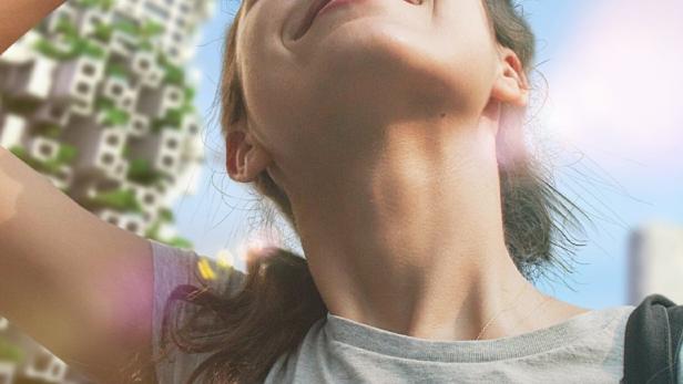 Eine Frau blickt lächelnd in die Sonne, im Hintergrund ein Gebäude mit viel Grün.