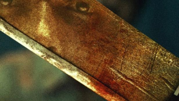 Das Filmplakat für „Indian Predator: The Butcher of Delhi“ zeigt eine Machete mit Blutspuren vor einem dunklen Hintergrund.