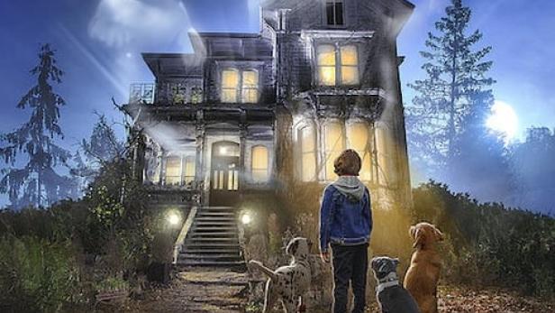 Ein Junge steht vor einem Spukhaus mit drei Hunden und den Geisterbildern von Welpen über dem Haus.
