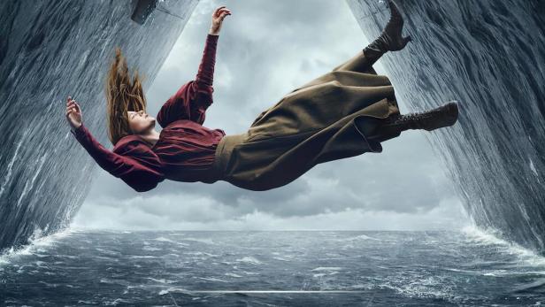 Eine Frau im Stil des späten 19. Jahrhunderts fällt zwischen zwei riesigen Schiffen ins Meer.