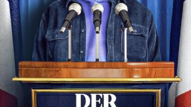 Ein Mann steht am Rednerpult vor einer französischen Flagge für „Der Wahlkämpfer“.