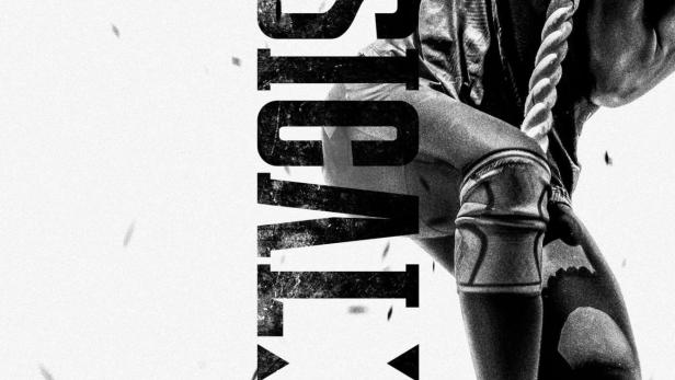 Ein Mann klettert an einem Seil hoch, im Hintergrund der Schriftzug „Physical: 100“.