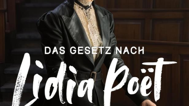 Eine Frau im Stil des späten 19. Jahrhunderts steht vor einem Schreibtisch mit Büchern, im Hintergrund der Titel „Das Gesetz nach Lidia Poët“.