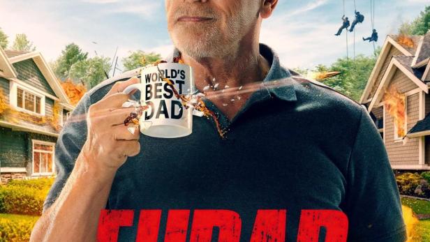 Arnold Schwarzenegger hält eine Tasse mit der Aufschrift „World's Best Dad“ vor einem explodierenden Vorort.