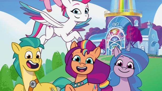 Die Charaktere aus „My Little Pony: Tell Your Tale“ vor einem bunten Leuchtturm.