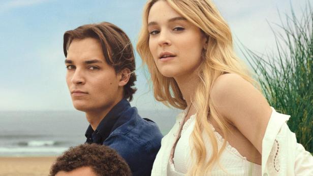 Drei junge Menschen sitzen am Strand vor dem Filmtitel „Knokke Off“.