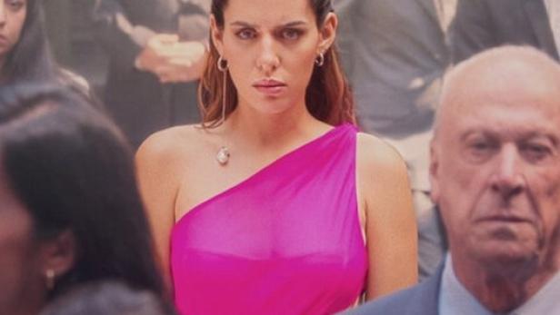 Eine Frau in einem pinkfarbenen Kleid steht im Mittelpunkt des Posters für „Pacto de Silencio“.