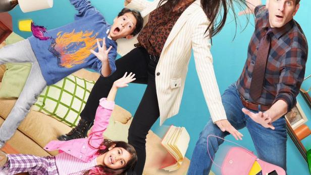 Die Familie steht vor einem hellblauen Hintergrund, auf dem der Titel „Children Ruin Everything“ steht.