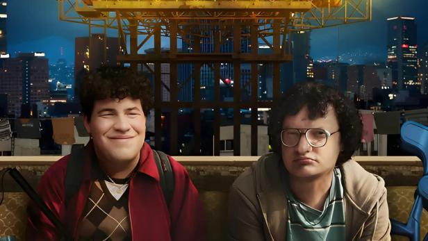 Das Filmplakat für „Ojitos de Huevo“ zeigt zwei junge Männer vor einer Skyline.