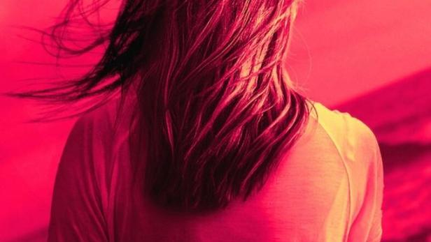 Eine Frau steht am Meer, im Vordergrund der Titel „American Nightmare“.