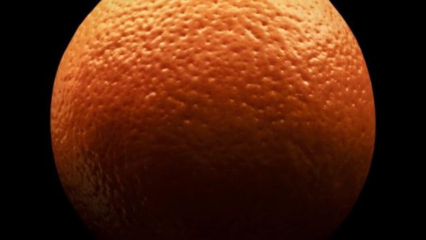 Eine Nahaufnahme einer Orange vor einem schwarzen Hintergrund.