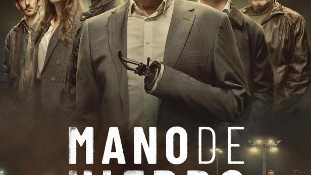 Das Filmplakat zu „Mano de Hierro“ zeigt eine Gruppe von Personen vor einem Hafen mit Containern.