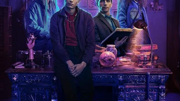 Das Poster für „Dead Boy Detectives“ zeigt vier junge Detektive an einem Tisch voller okkulter Gegenstände.
