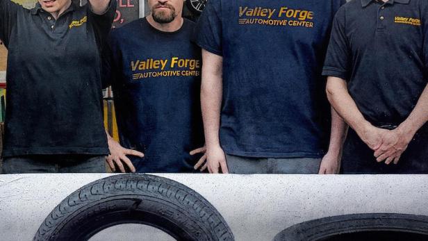 Das Werbeplakat für die Serie „Tires“ zeigt vier Mechaniker vor Reifen.