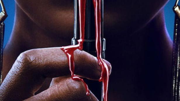 Eine Frau hält einen roten Lippenstift vor ihren Lippen, der mit Farbe bedeckt ist.