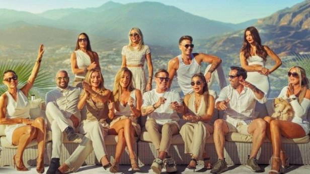 Das Ensemble der Netflix-Serie „Making It in Marbella“ posiert vor einer Bergkulisse.
