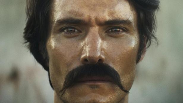 Ein Porträt eines Mannes mit Schnurrbart, der auf dem Filmplakat für „Cien Años de Soledad“ zu sehen ist.