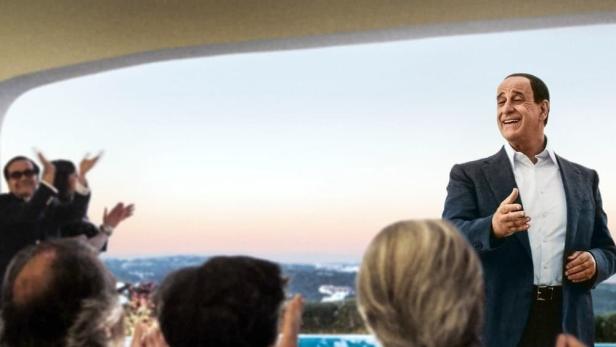 Ein Mann hält eine Rede vor einer Gruppe von Zuhörern im Film „Loro“.