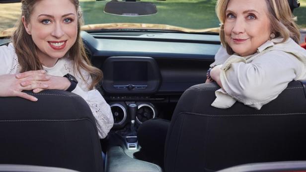 Chelsea Clinton und Hillary Clinton sitzen in einem roten Cabrio für die Apple TV+ Serie „Gutsy“.
