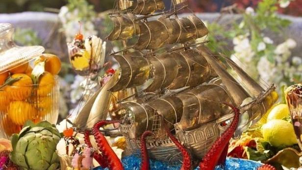 Das Netflix-Serienplakat für „Crazy Delicious“ zeigt ein reichhaltiges Buffet mit einem Schiffsmodell und Krakenarmen.