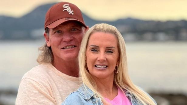 Ein Paar, vermutlich Steff Jerkel und Peggy Jerkel, posiert vor einer Küstenlandschaft.