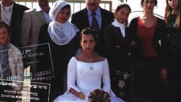 Das Filmplakat für „Die syrische Braut“ mit der Braut und ihrer Familie vor einem Grenzzaun.