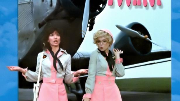 Das Filmplakat für „Zwei himmlische Töchter“ mit Iris Berben und Ingrid Steeger vor einem Flugzeug.