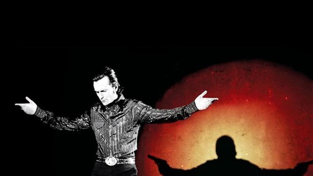 Ein Mann in glitzerndem Hemd posiert vor dem roten Titelbild von „White Lightnin‘“.