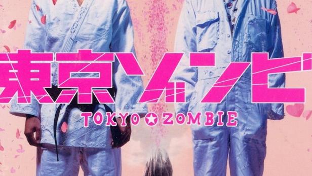 Das Filmplakat für „Tokyo Zombie“ zeigt zwei Männer, die über einer Stadt stehen, mit einem Vulkan im Hintergrund.