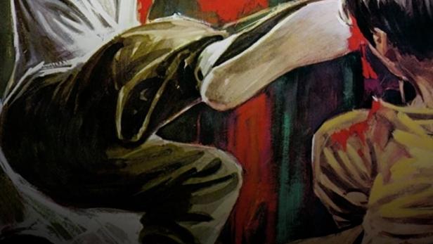 Ein Mann mit einer Kette in der Hand tritt einen anderen Mann, beide sind mit Blut bedeckt.