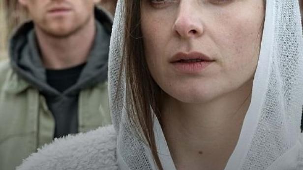 Das Filmplakat für „Die Whistleblowerin“ zeigt eine Frau mit Kopftuch und einen Mann im Hintergrund.