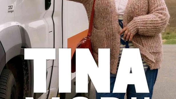 Eine Frau steht an einem Wohnmobil mit der Aufschrift „Tina Mobil“.